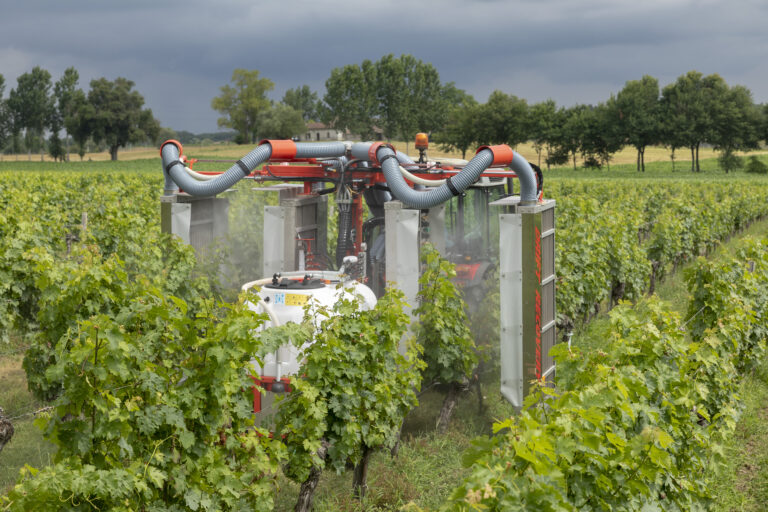 un pulvérisateur en action dans les vignes au cours d'une formation