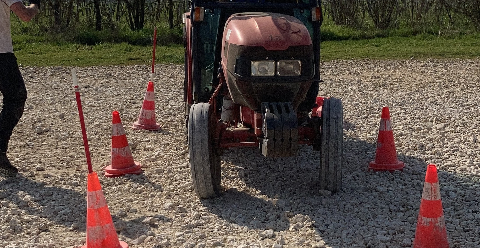 Homme sur un tracteur manoeuvrant entre des plots conduite