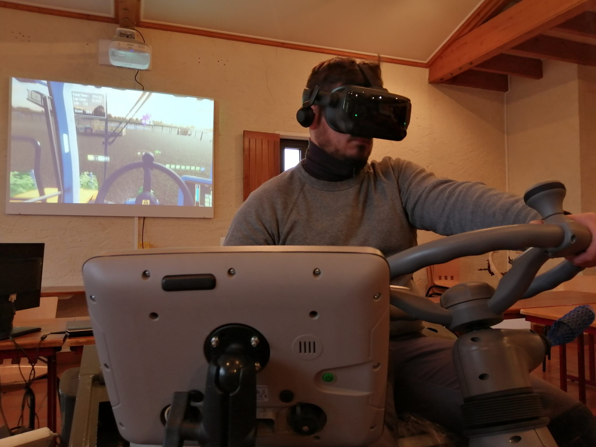 Homme avec un casque dans un simulateur de conduite d'engin agricole