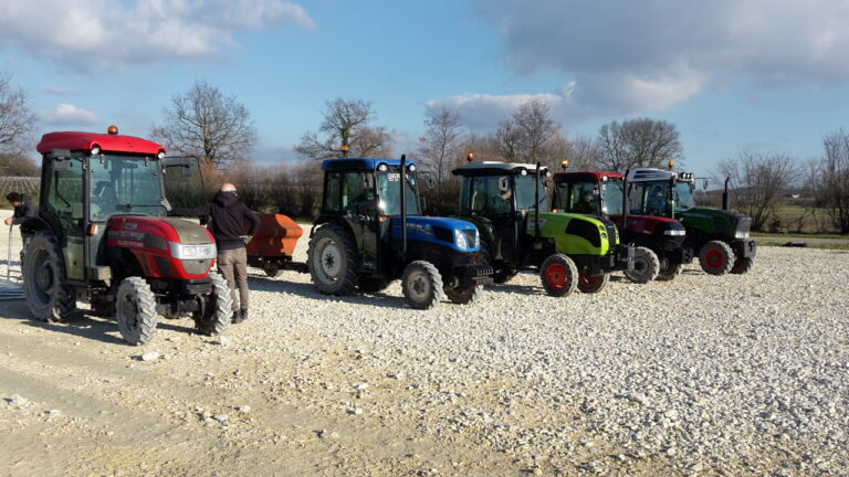 5 tracteurs agricoles alignés sur un sol caillouteux conduite travail du sol